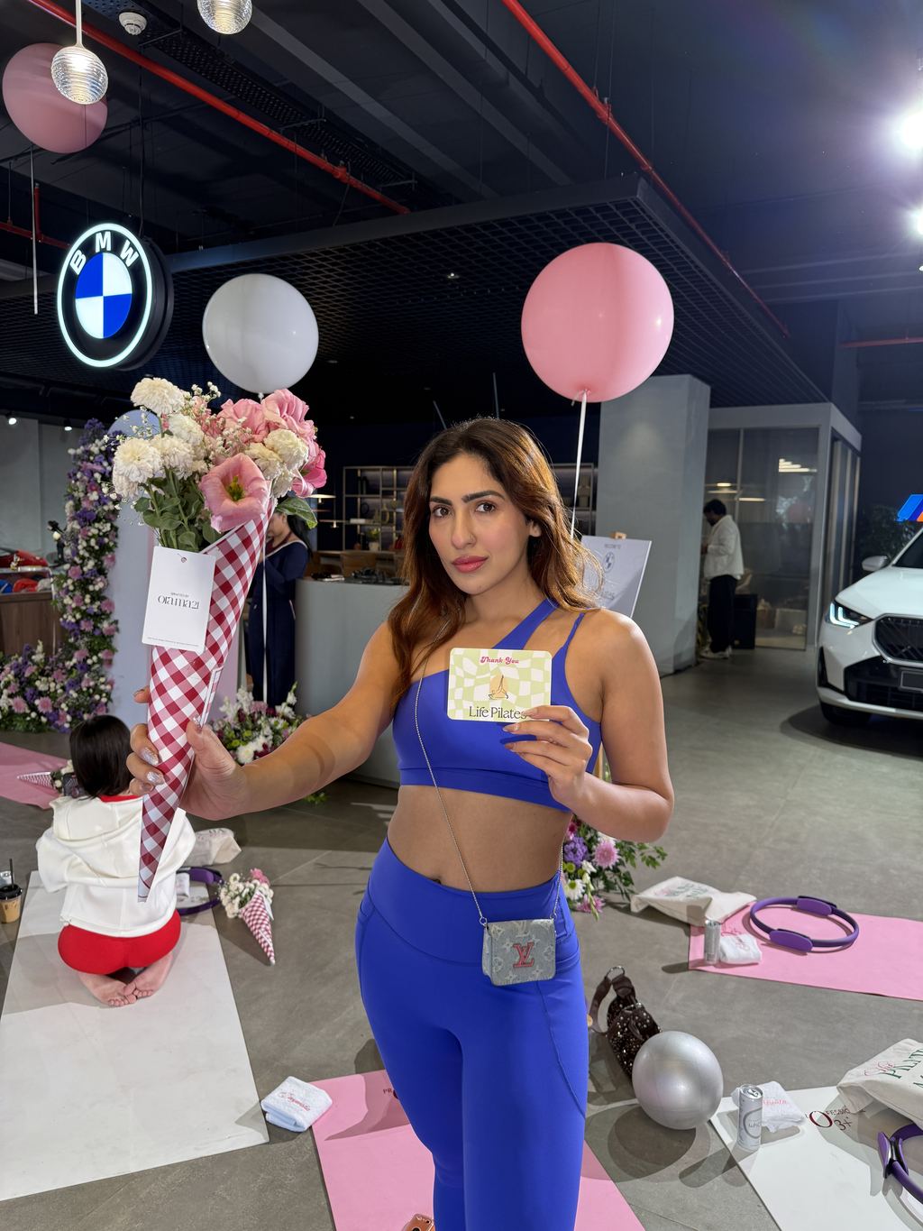 A guest at an off-site Life Pilates class with flowers and a thank-you card