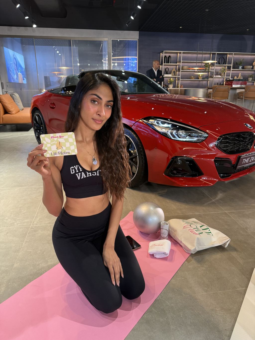 A guest holding a Life Pilates thank-you card after an off-site session