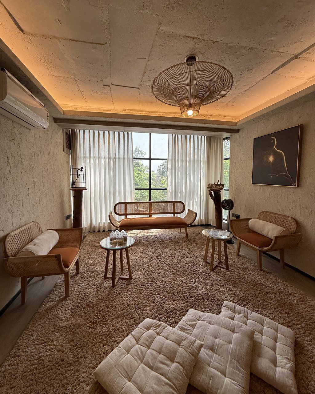 The Life Pilates lounge — cane benches, floor cushions and a window onto the trees